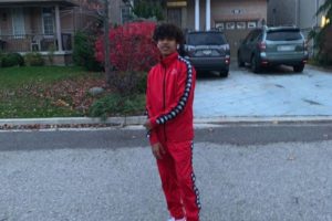 Slyky rapper standing on the street in red tracksuit