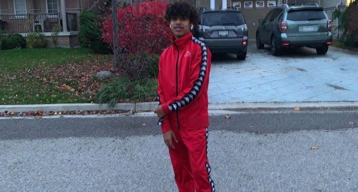 Slyky rapper standing on the street in red tracksuit