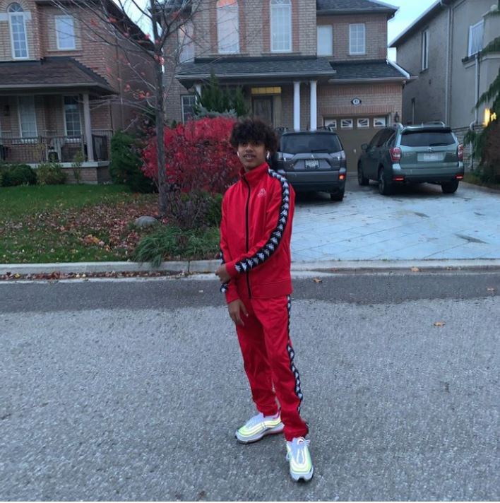 Slyky rapper standing on the street in red tracksuit