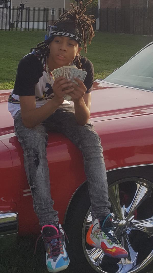 keph-swag rapper holding money while seating on a car