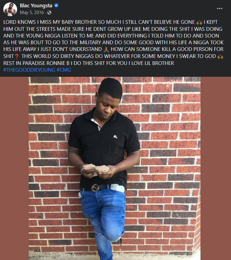 A person standing in front of a brick wall

Description automatically generated