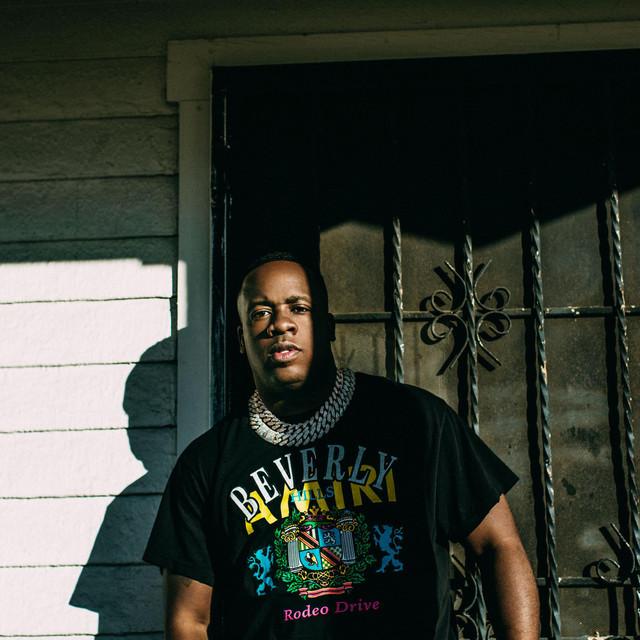 Key Glock: The Heir To The PRE Empire 4 A person standing in front of a gateDescription automatically generated with medium confidence