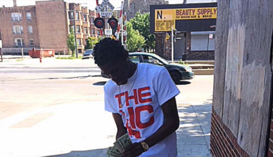 The Legacy Of T.Roy: The Chiraq Rambo 60 A person sitting on a sidewalk
Description automatically generated with low confidence