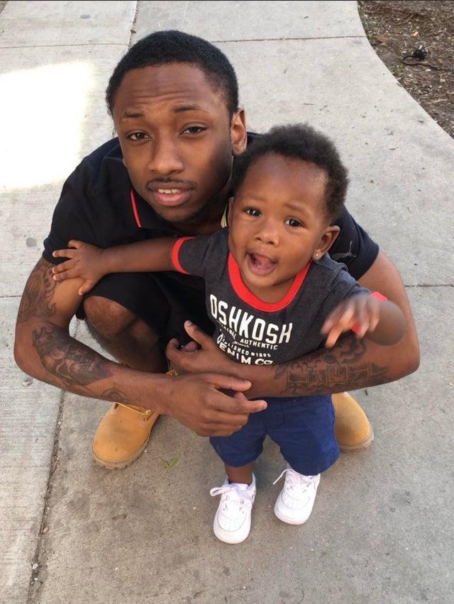 The Legacy Of T.Roy: The Chiraq Rambo 52 A person holding a baby
Description automatically generated with medium confidence