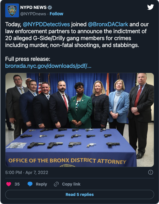 A group of people standing in front of a table with guns

Description automatically generated with medium confidence