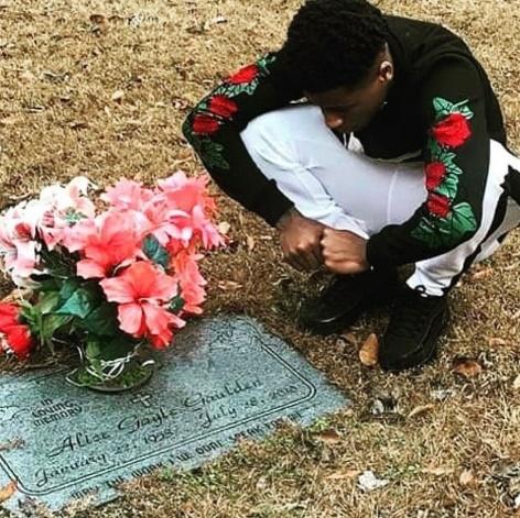 A person kneeling on the ground next to a bouquet of flowers
Description automatically generated with low confidence