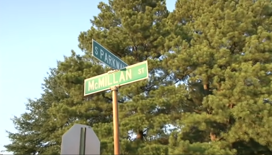 A street sign next to a stop sign

Description automatically generated with medium confidence