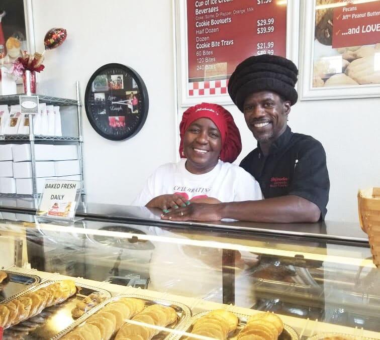 A person and person behind a counter with a tray of donutsDescription automatically generated with low confidence