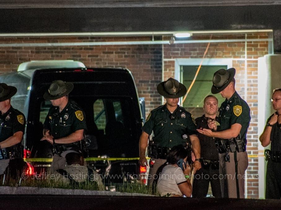 A group of police officers standing in front of a car
Description automatically generated with low confidence